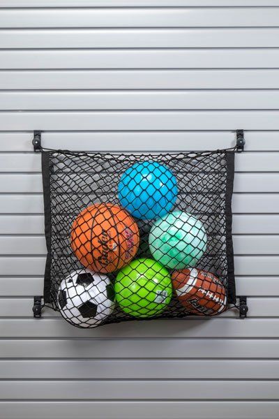 A bunch of balls are in a net on a wall.