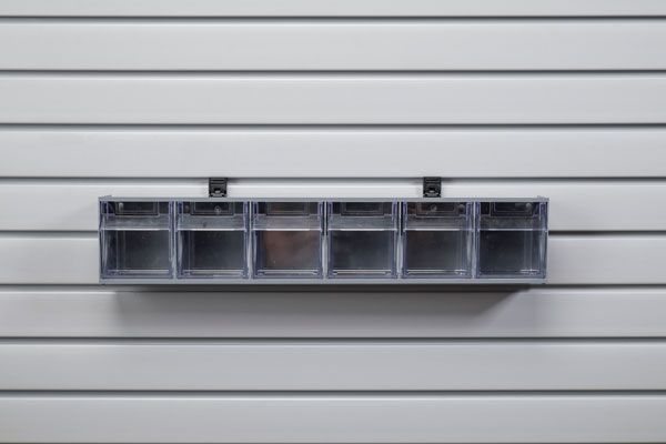 A shelf with a bunch of bins hanging on a wall.