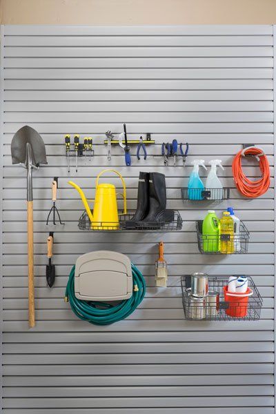 A wall with a bunch of gardening tools hanging on it.