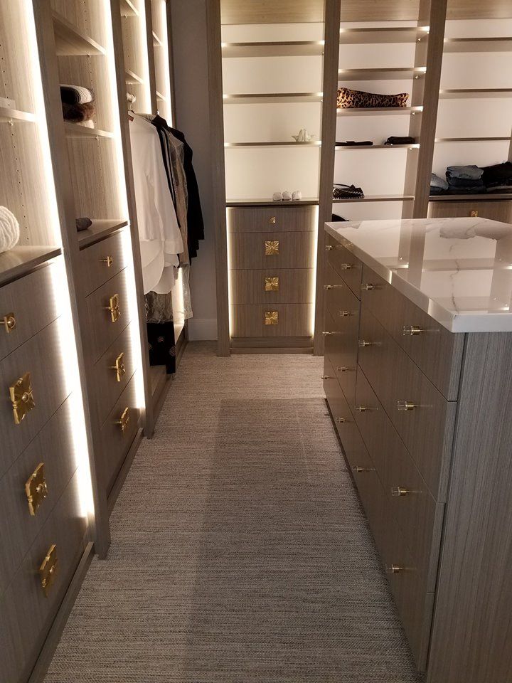 A walk in closet with lots of drawers and shelves