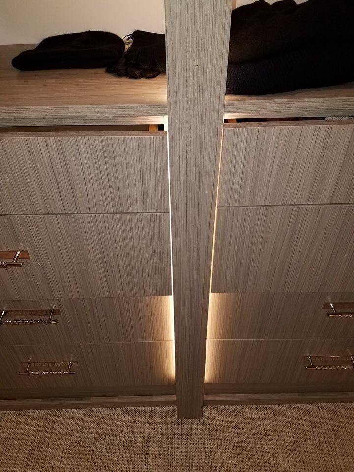 A closet with a lot of drawers and clothes in it.