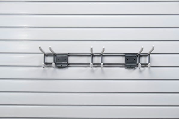 A hook is hanging on a white wall.