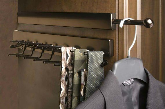 A suit is hanging on a hanger next to a tie rack