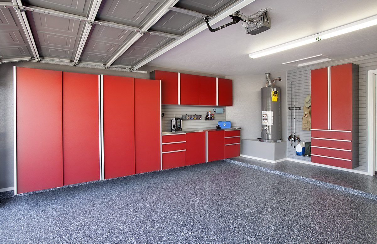 A clean, modern garage with red cabinets, a speckled floor, and a water heater installed along the wall.
