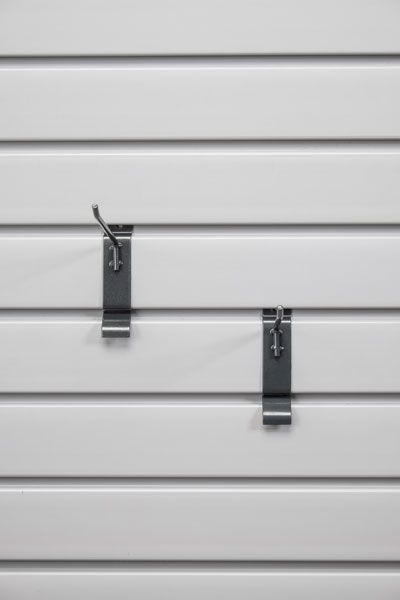 Two hooks are hanging on a white slat wall.