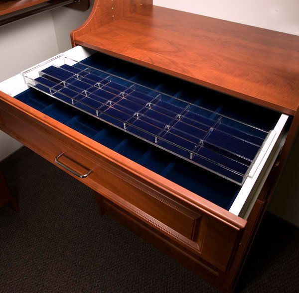 A wooden drawer filled with blue velvet and clear dividers