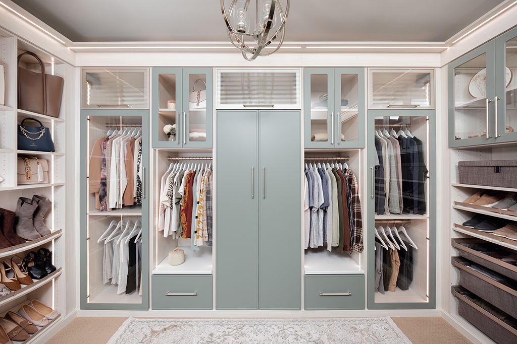 A walk in closet filled with lots of clothes and shoes.
