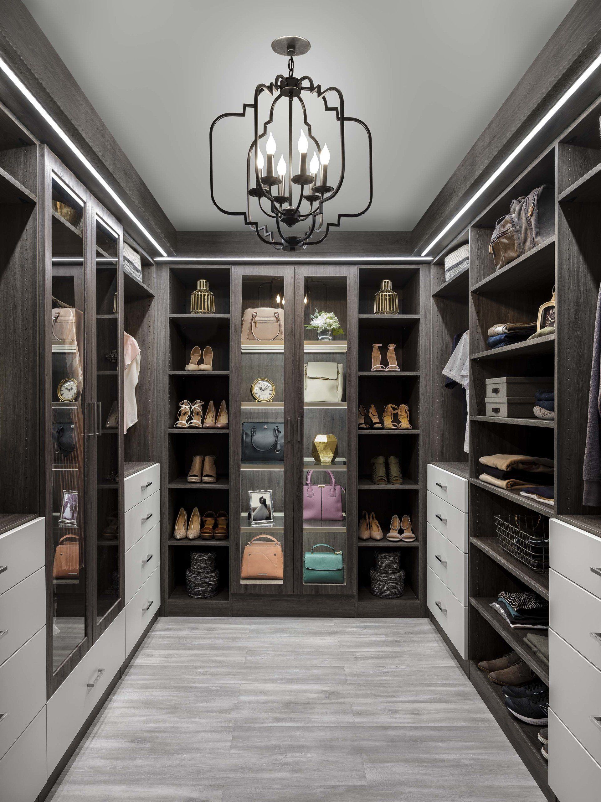 A walk in closet filled with lots of clothes and shoes.