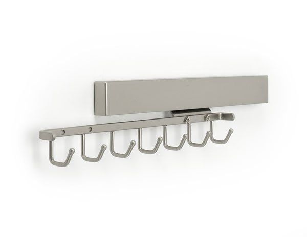 A stainless steel coat rack with hooks on a white wall.