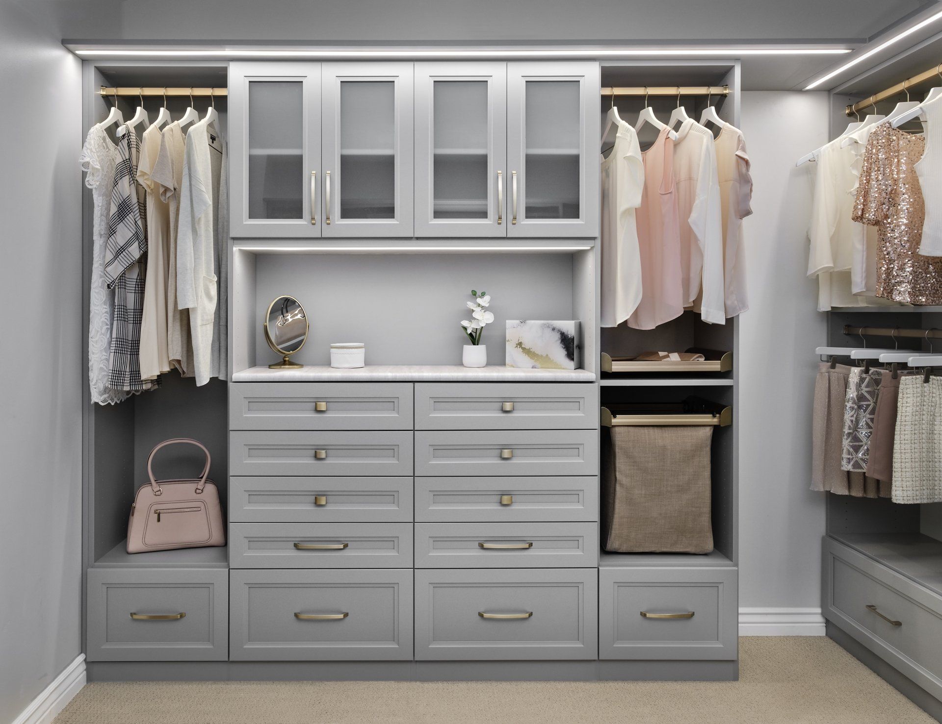 A walk in closet with lots of clothes and drawers.