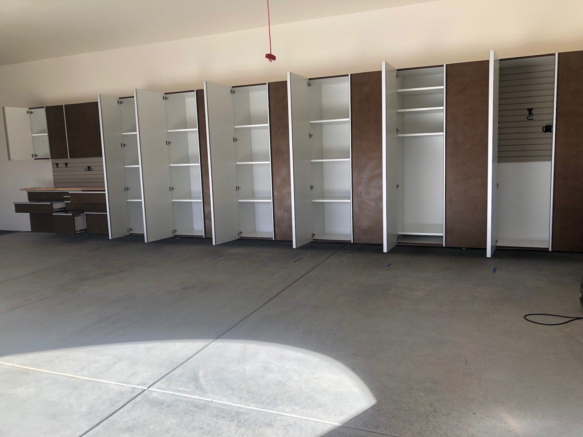 A large empty garage with lots of shelves and cabinets