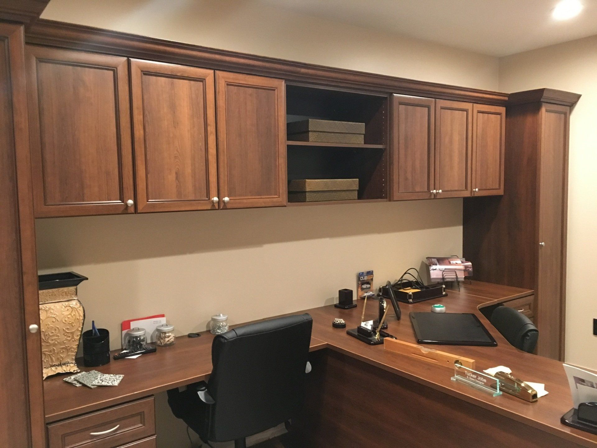 A home office with a desk , chair and cabinets