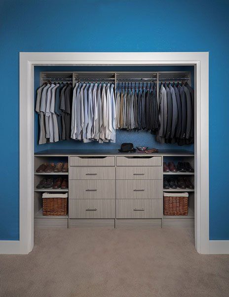 A walk in closet with blue walls and lots of clothes