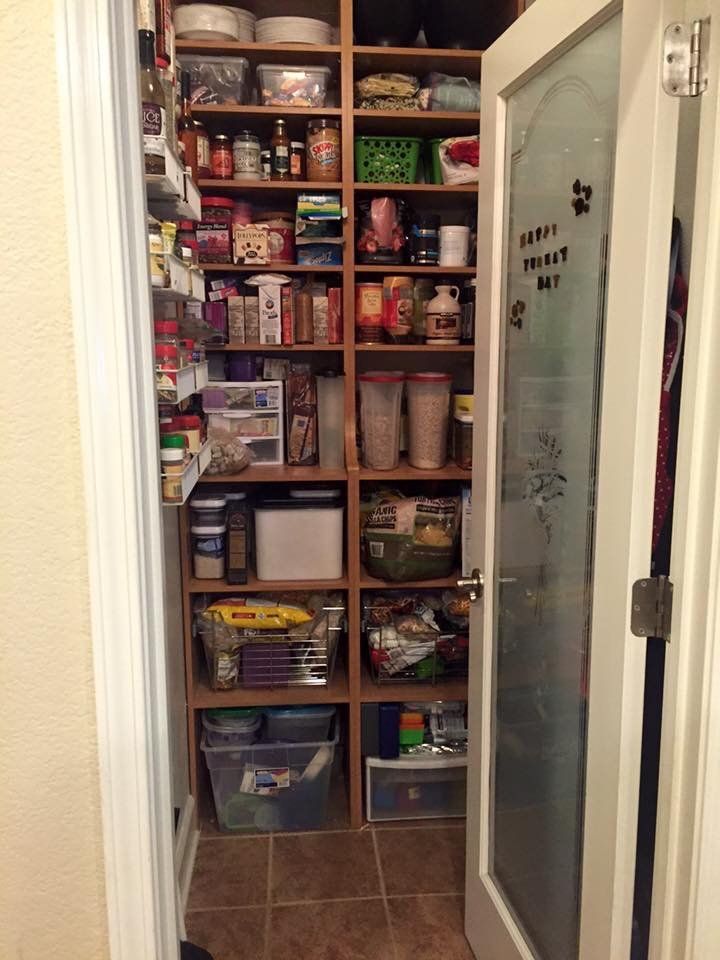 A pantry with lots of shelves and a glass door