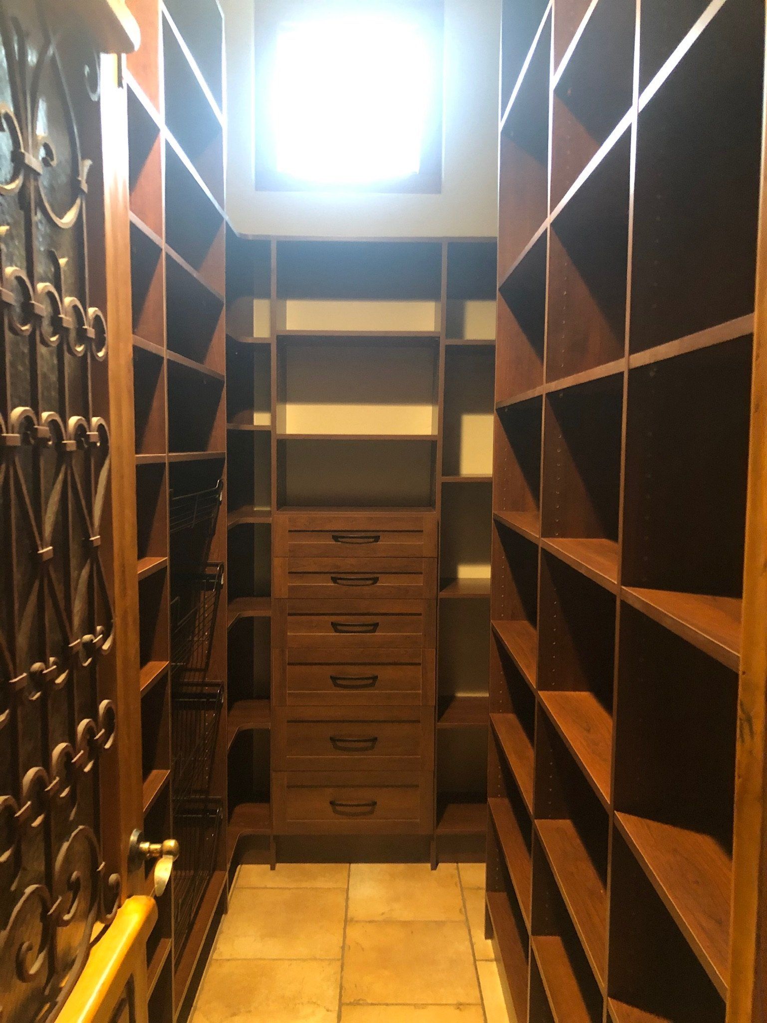 A walk in closet with lots of shelves and drawers