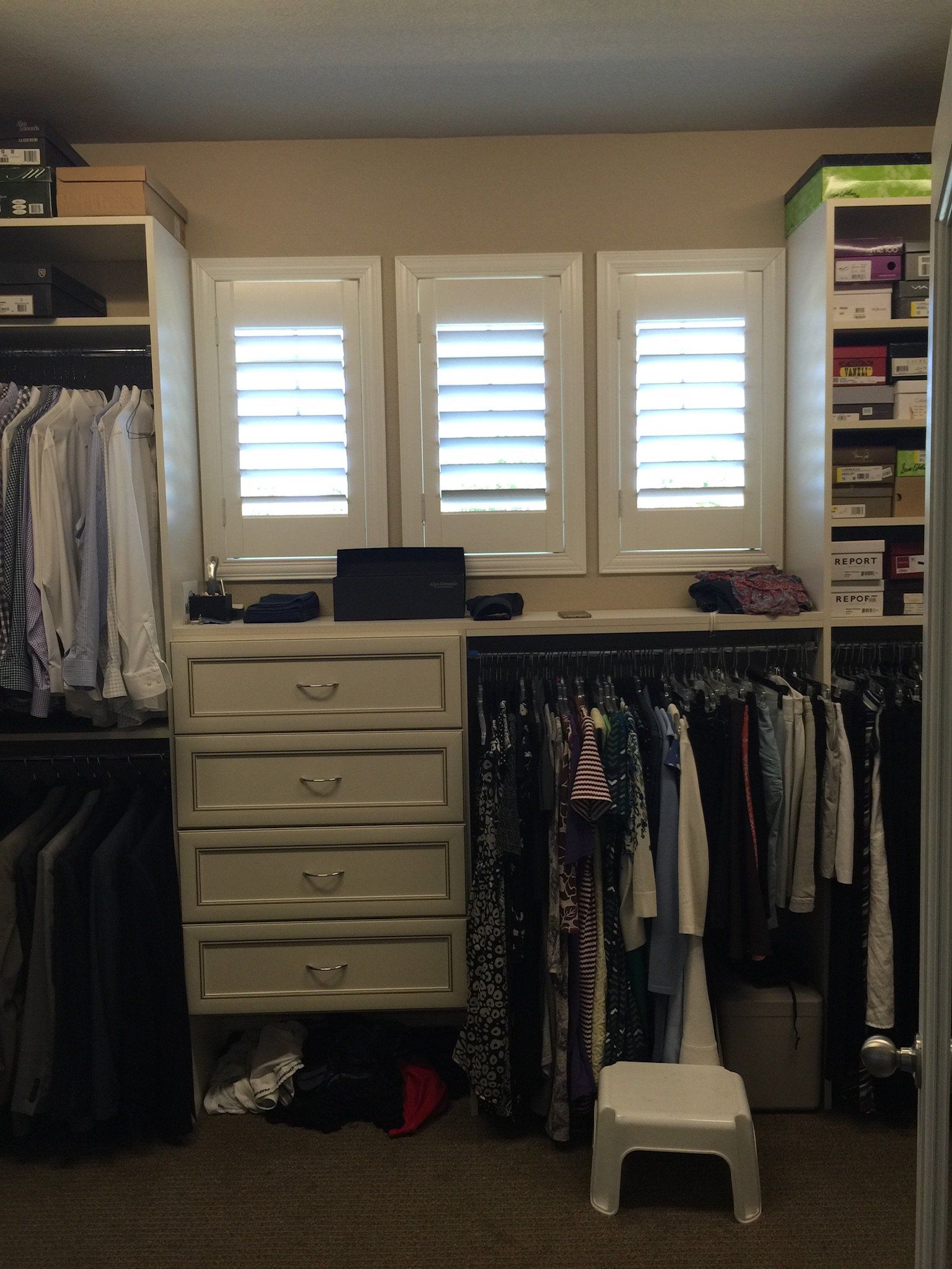 A walk in closet with lots of clothes and drawers