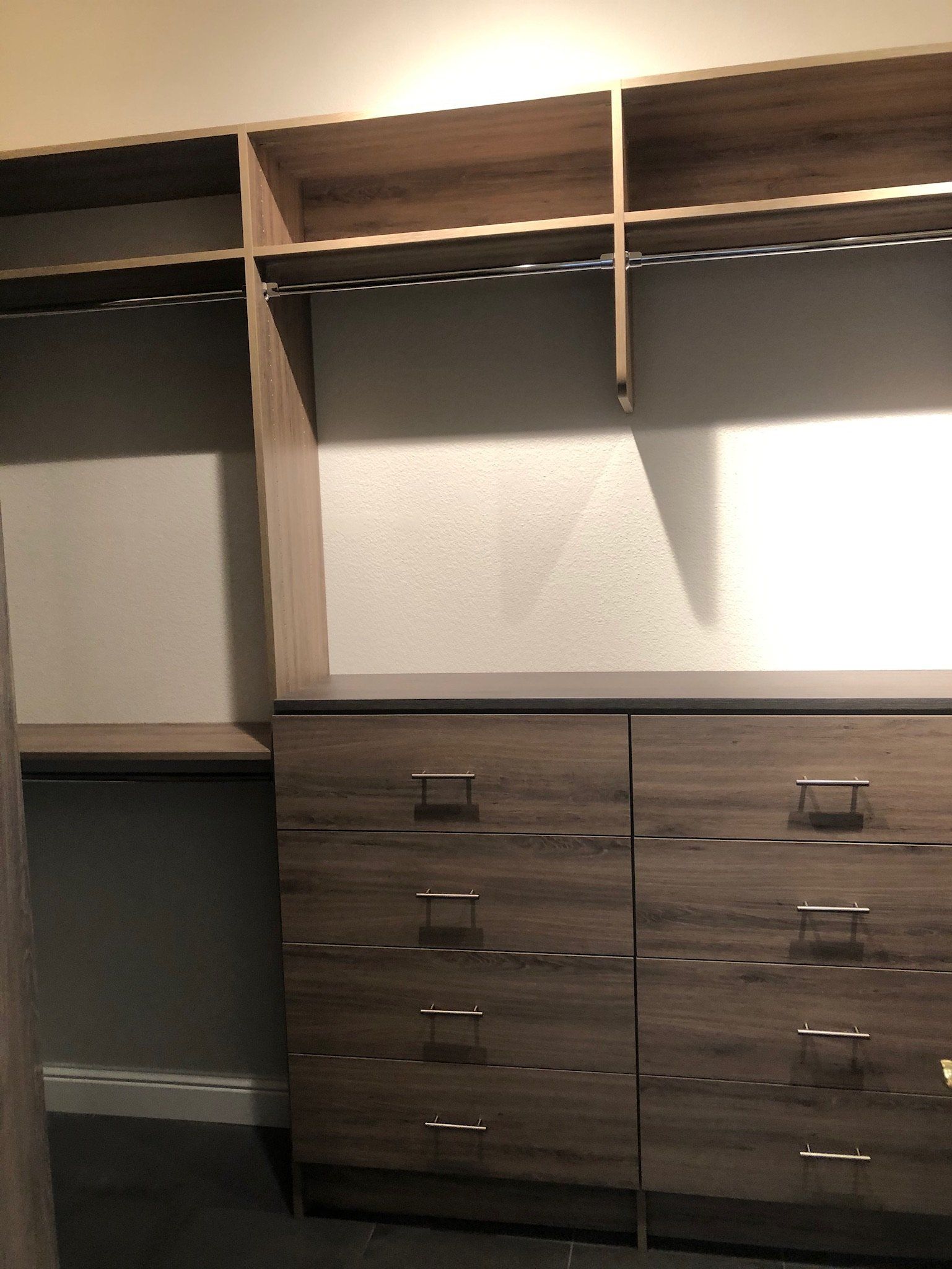 A walk in closet with lots of shelves and drawers