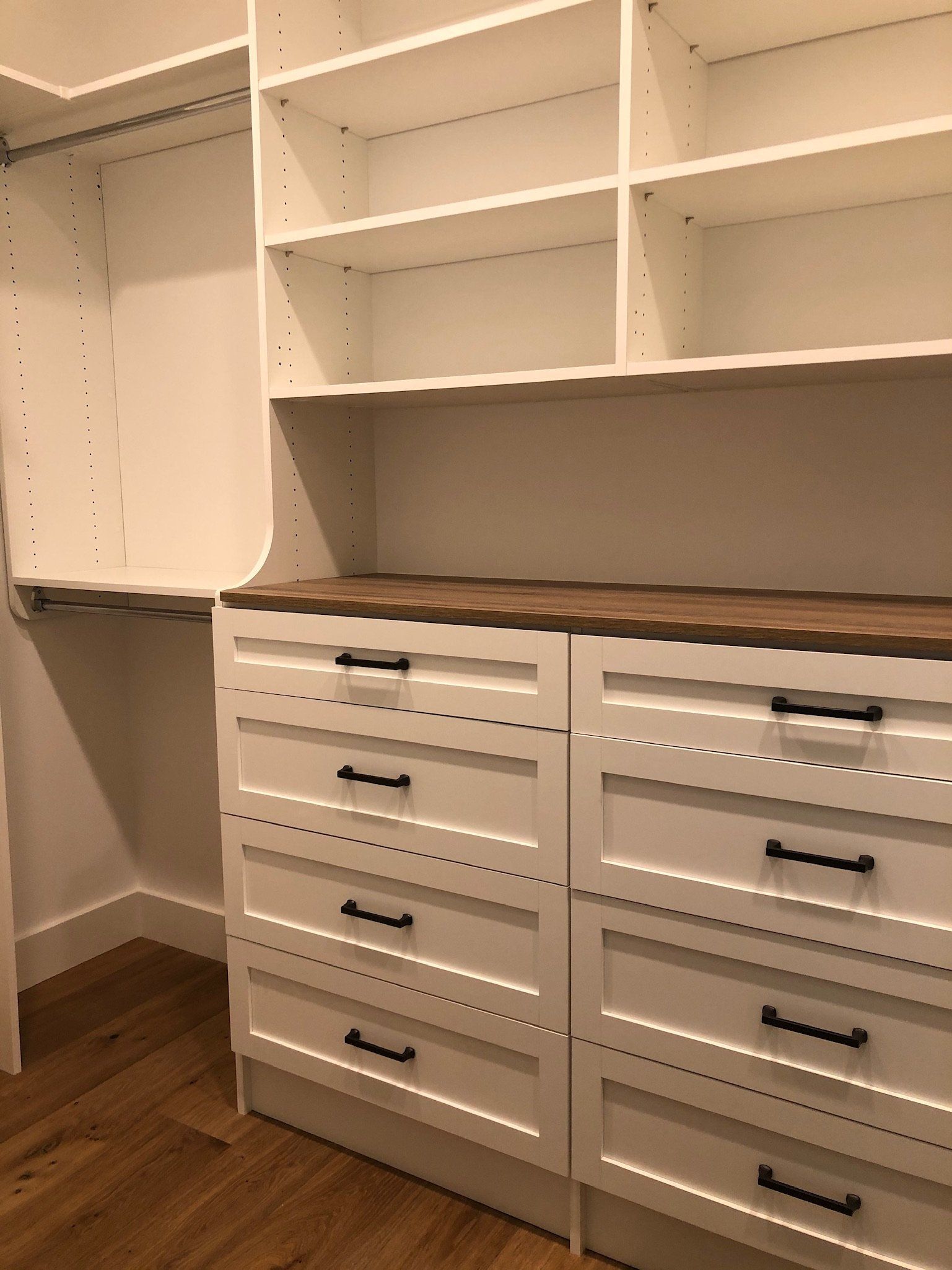A walk in closet with lots of shelves and drawers.