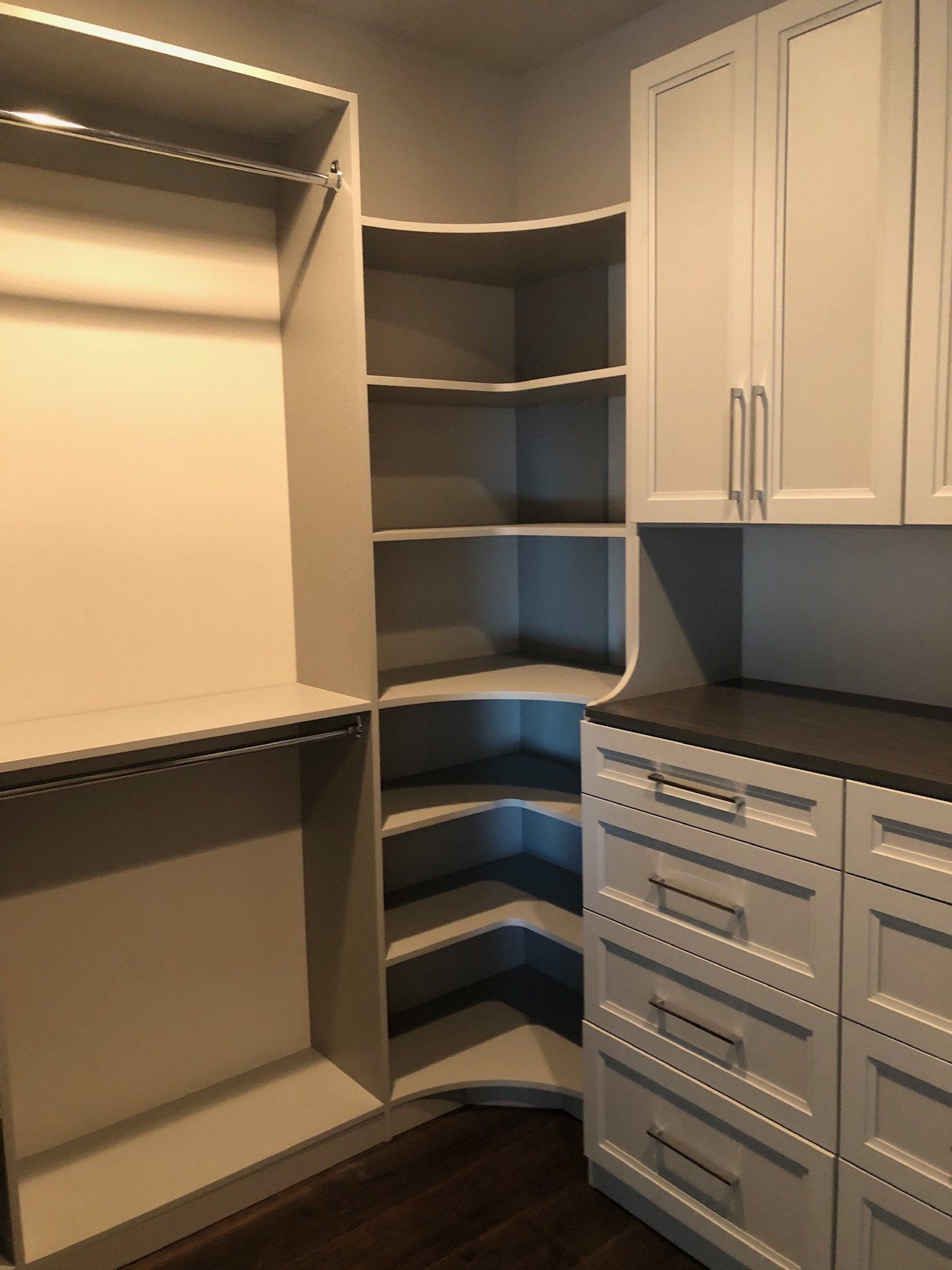 A walk in closet with lots of shelves and drawers
