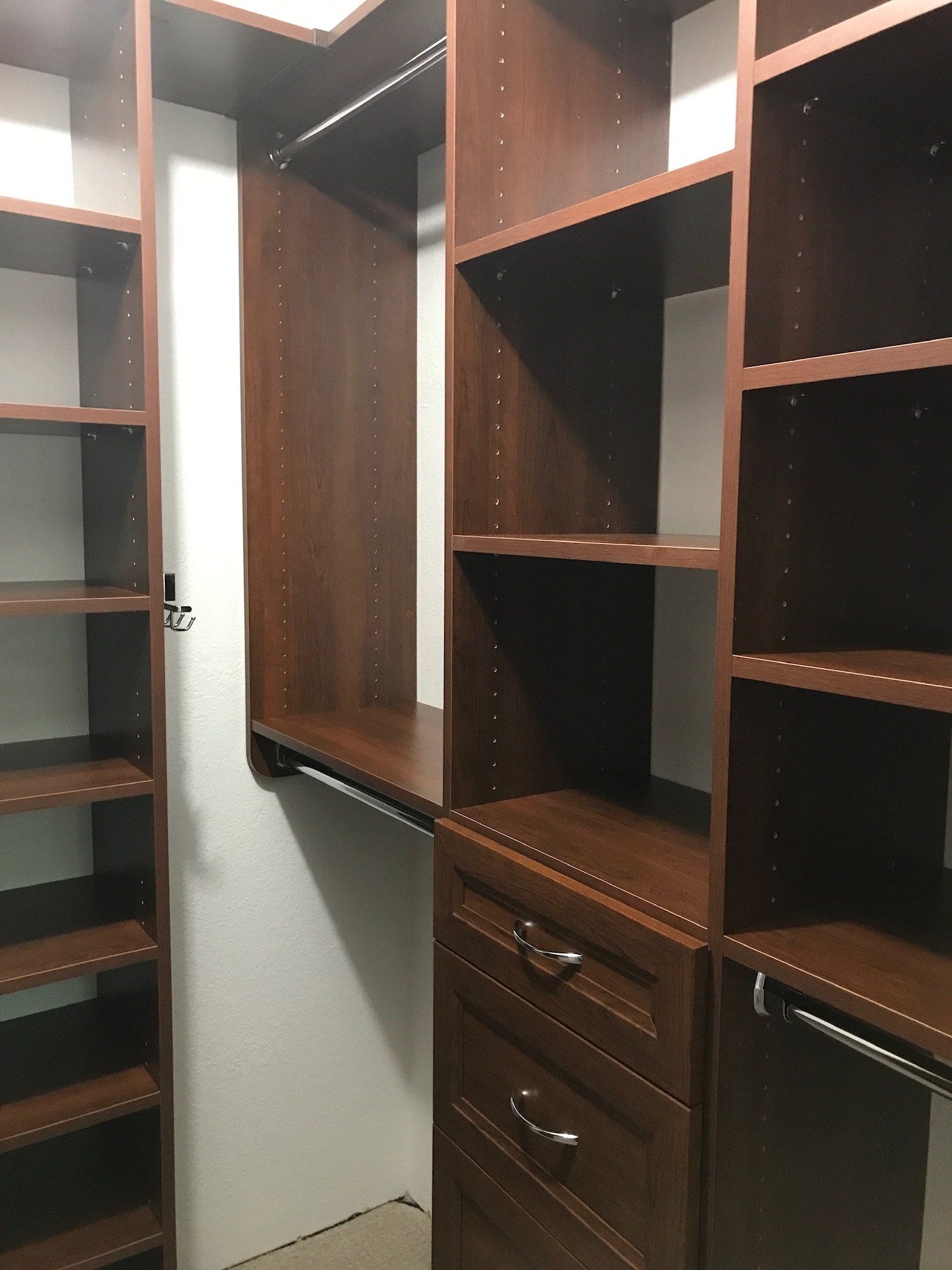 A walk in closet with lots of shelves and drawers