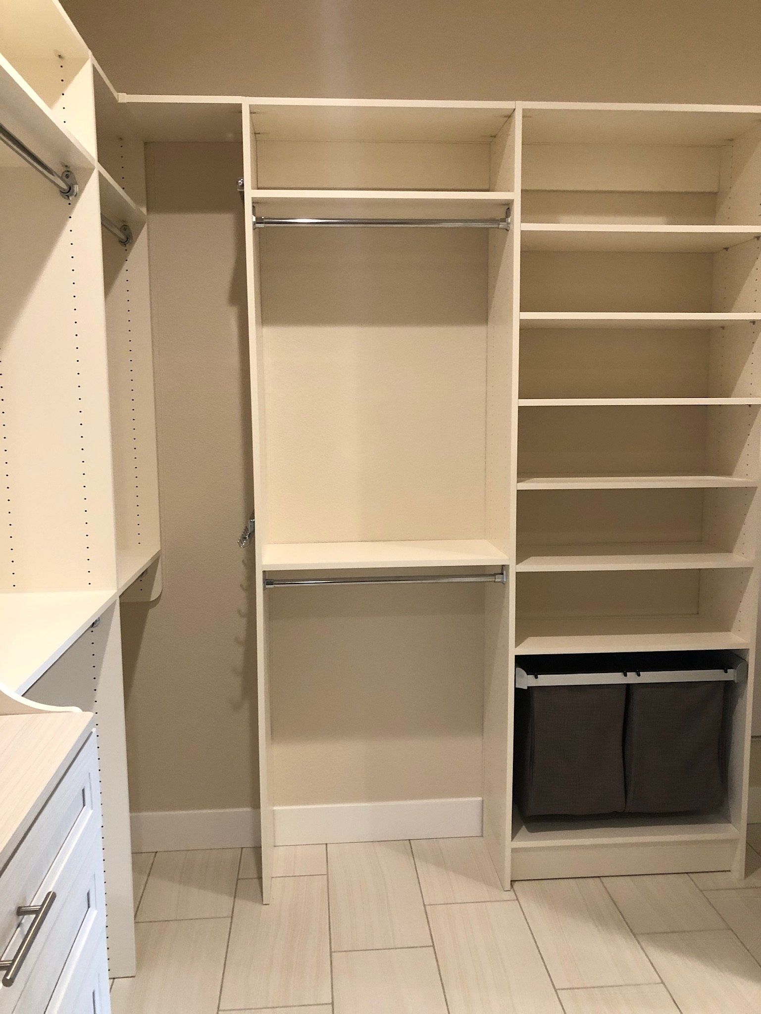 A walk in closet with lots of shelves and drawers