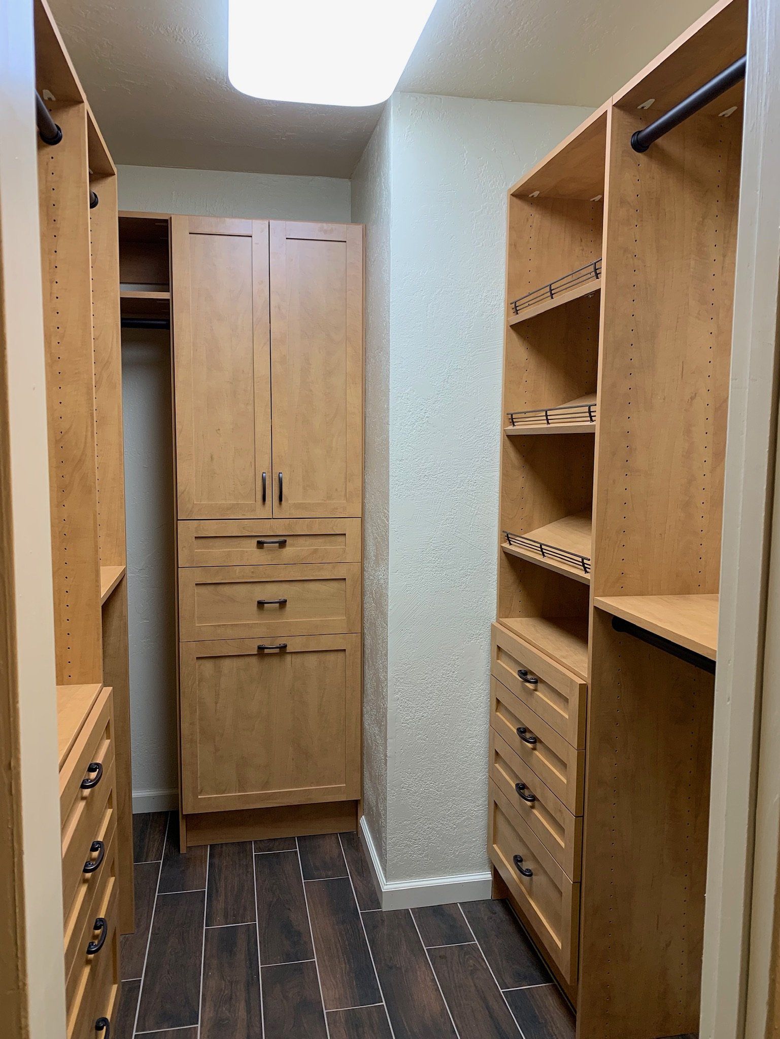 A walk in closet with wooden cabinets and shelves