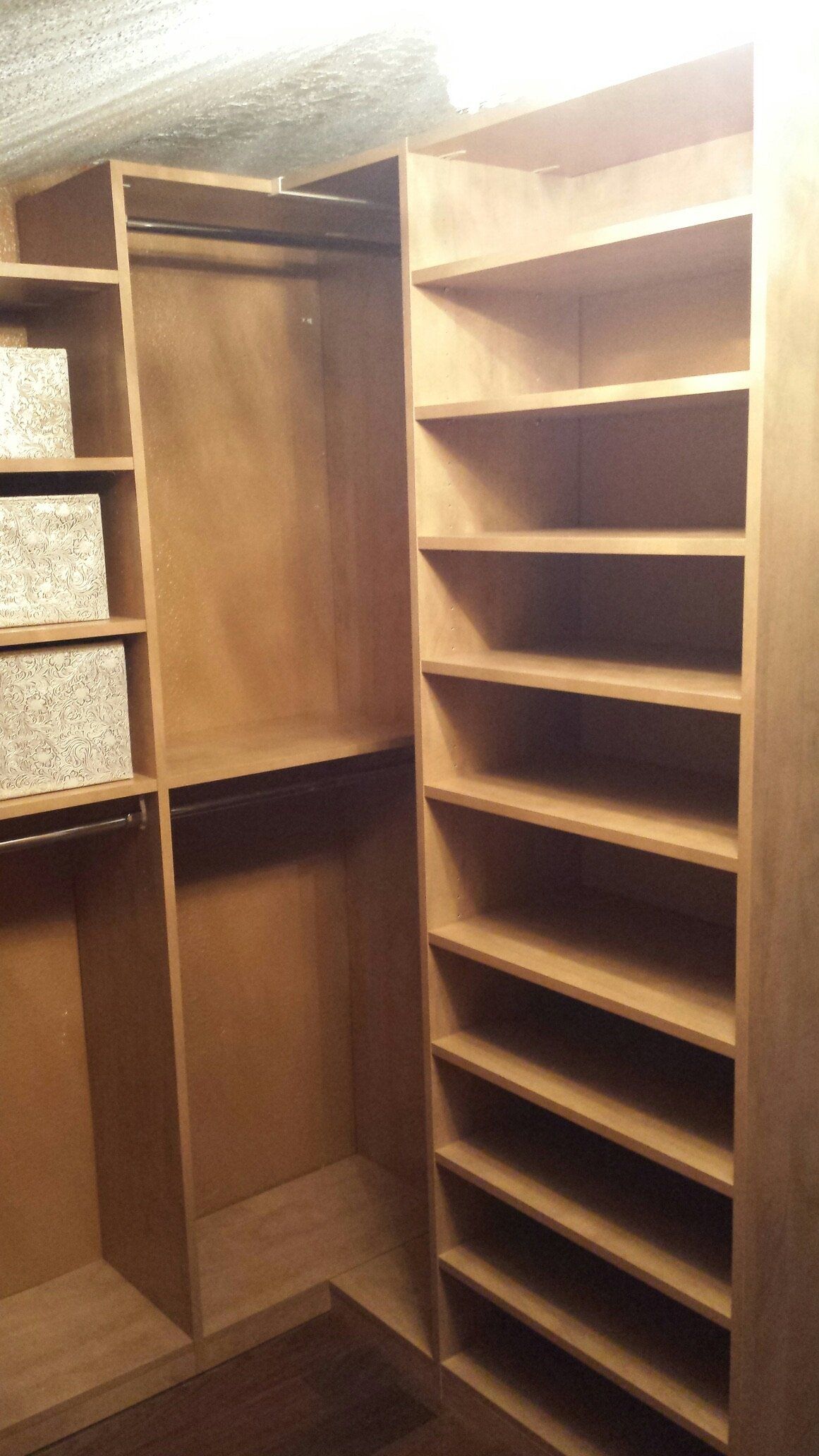 A walk in closet with lots of shelves and boxes.