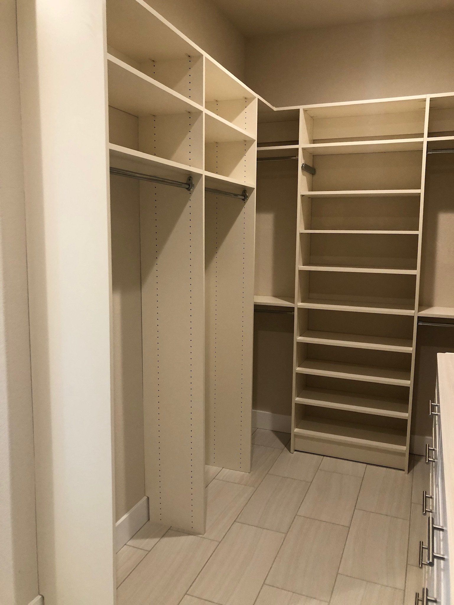 A walk in closet with lots of shelves and drawers
