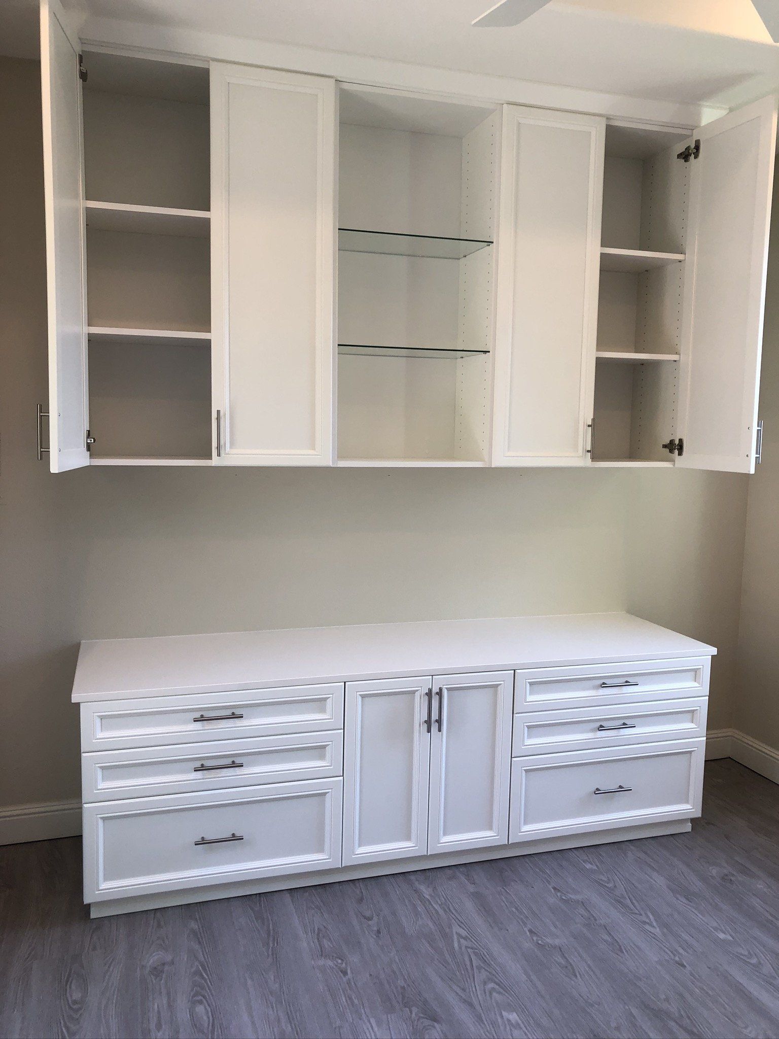 A white cabinet with the doors open in an empty room.