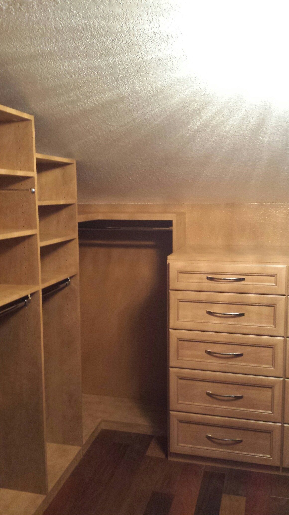 A walk in closet with lots of shelves and drawers.