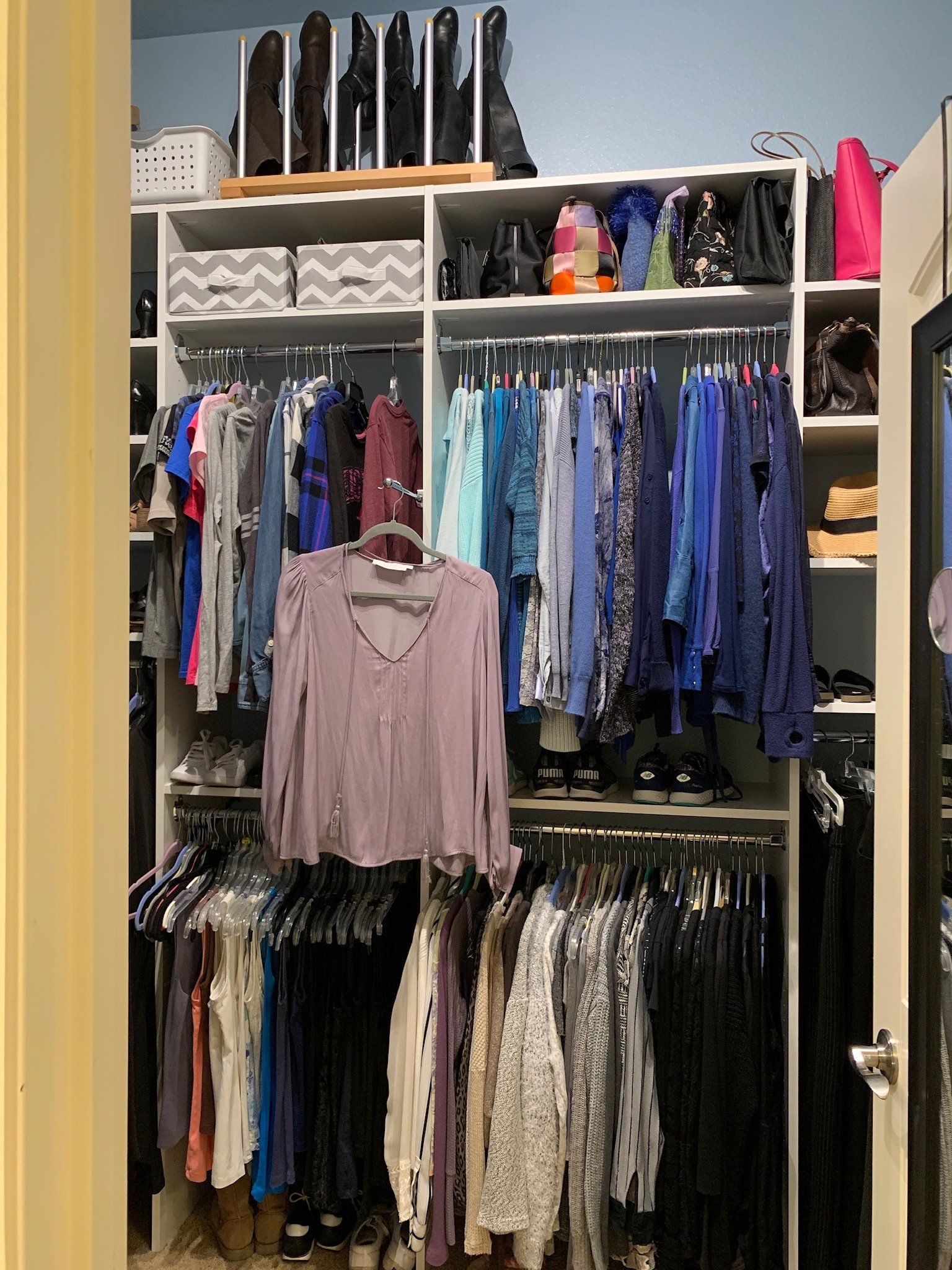A closet filled with lots of clothes and shoes.