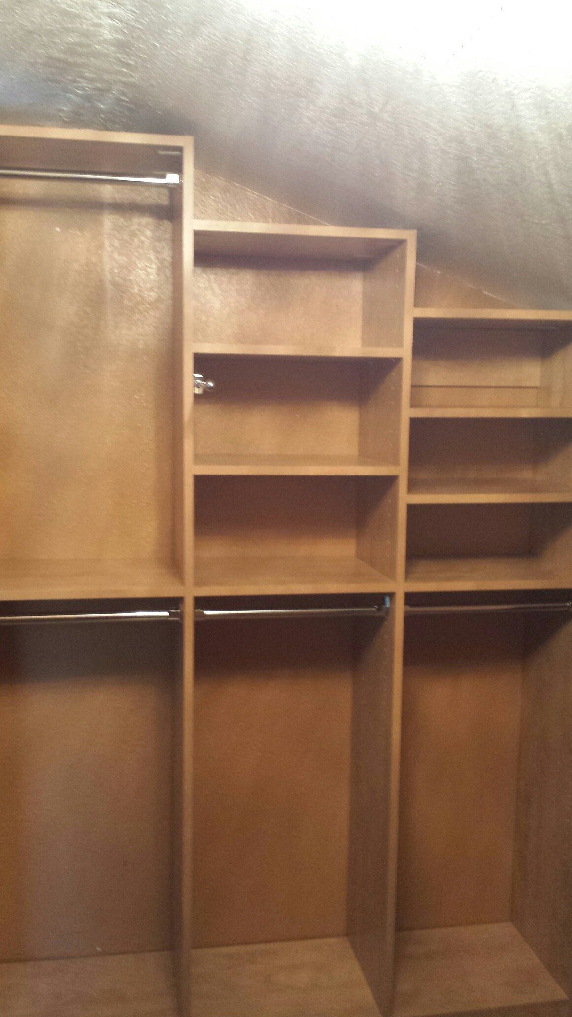 A walk in closet with lots of shelves and clothes racks.