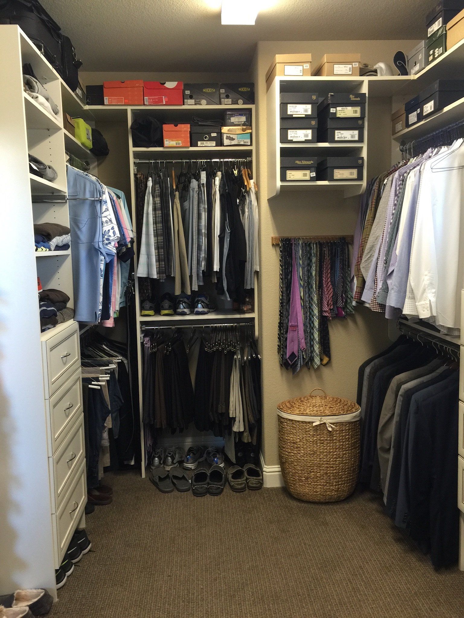 A walk in closet filled with lots of clothes and shoes.