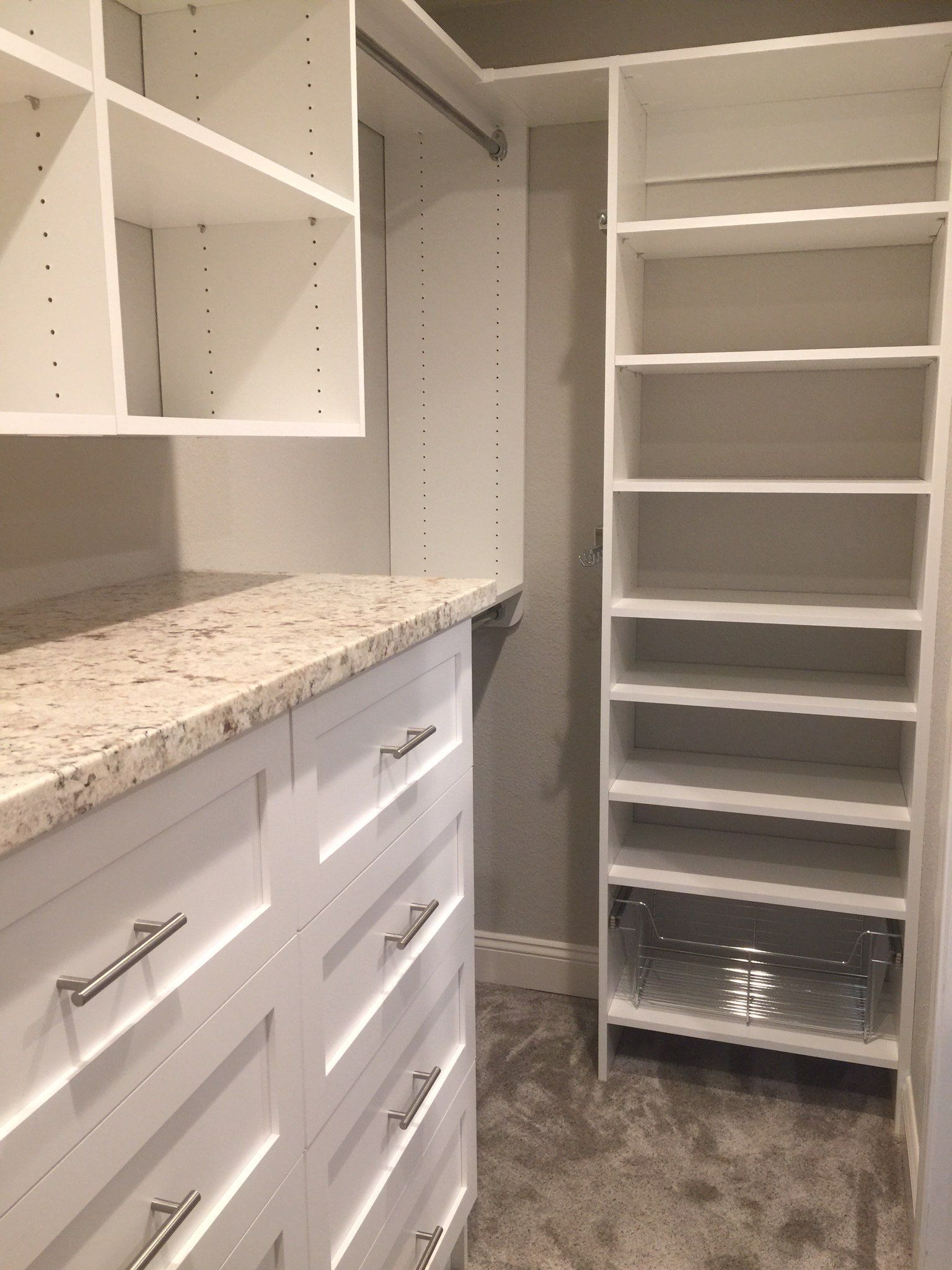A walk in closet with lots of shelves and drawers.