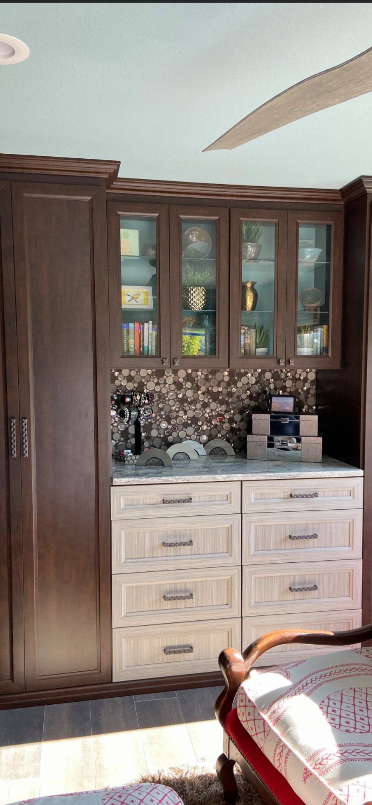 A living room with lots of cabinets and drawers and a ceiling fan.