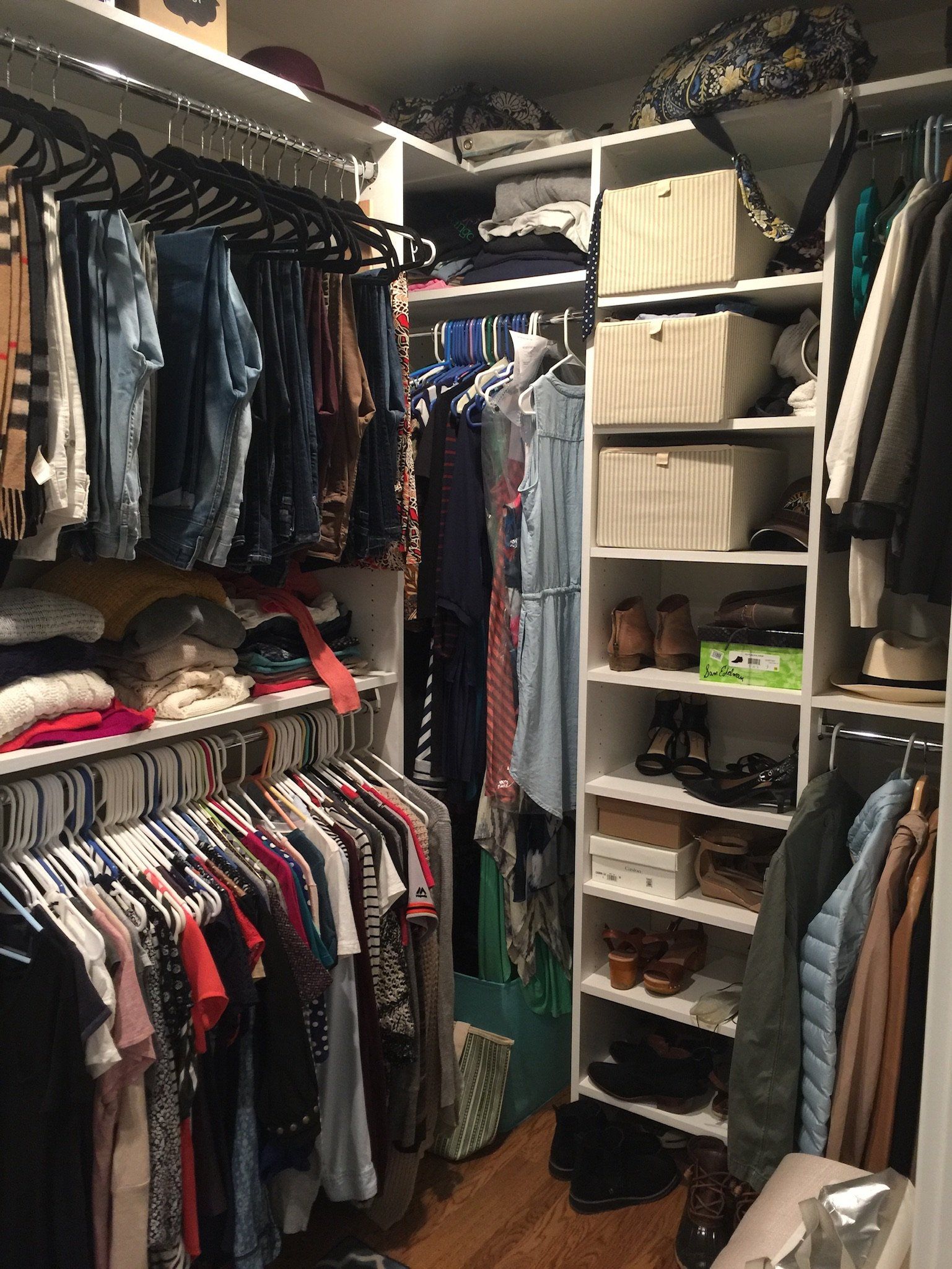 A walk in closet filled with lots of clothes and shoes.