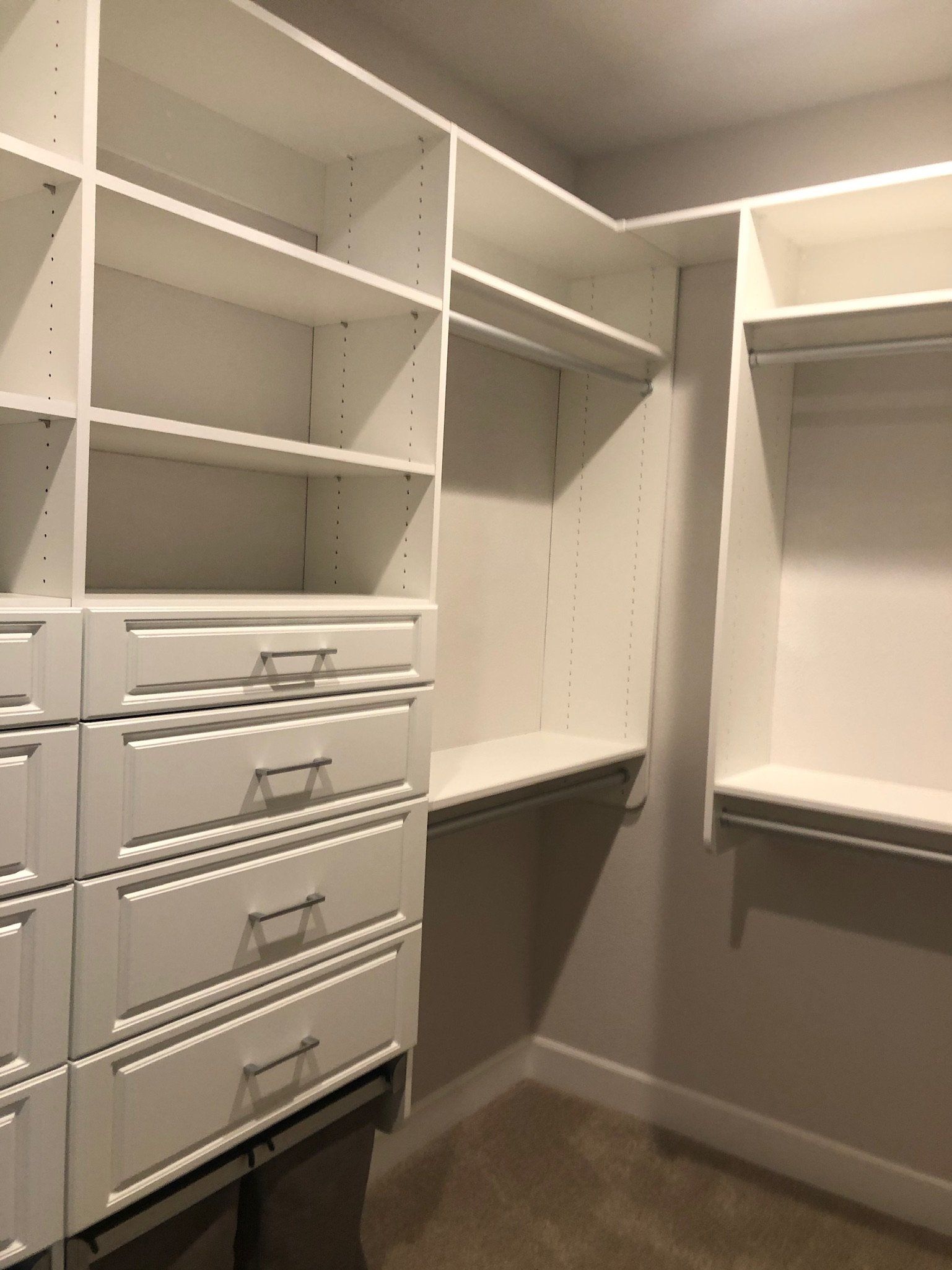 A walk in closet with lots of shelves and drawers