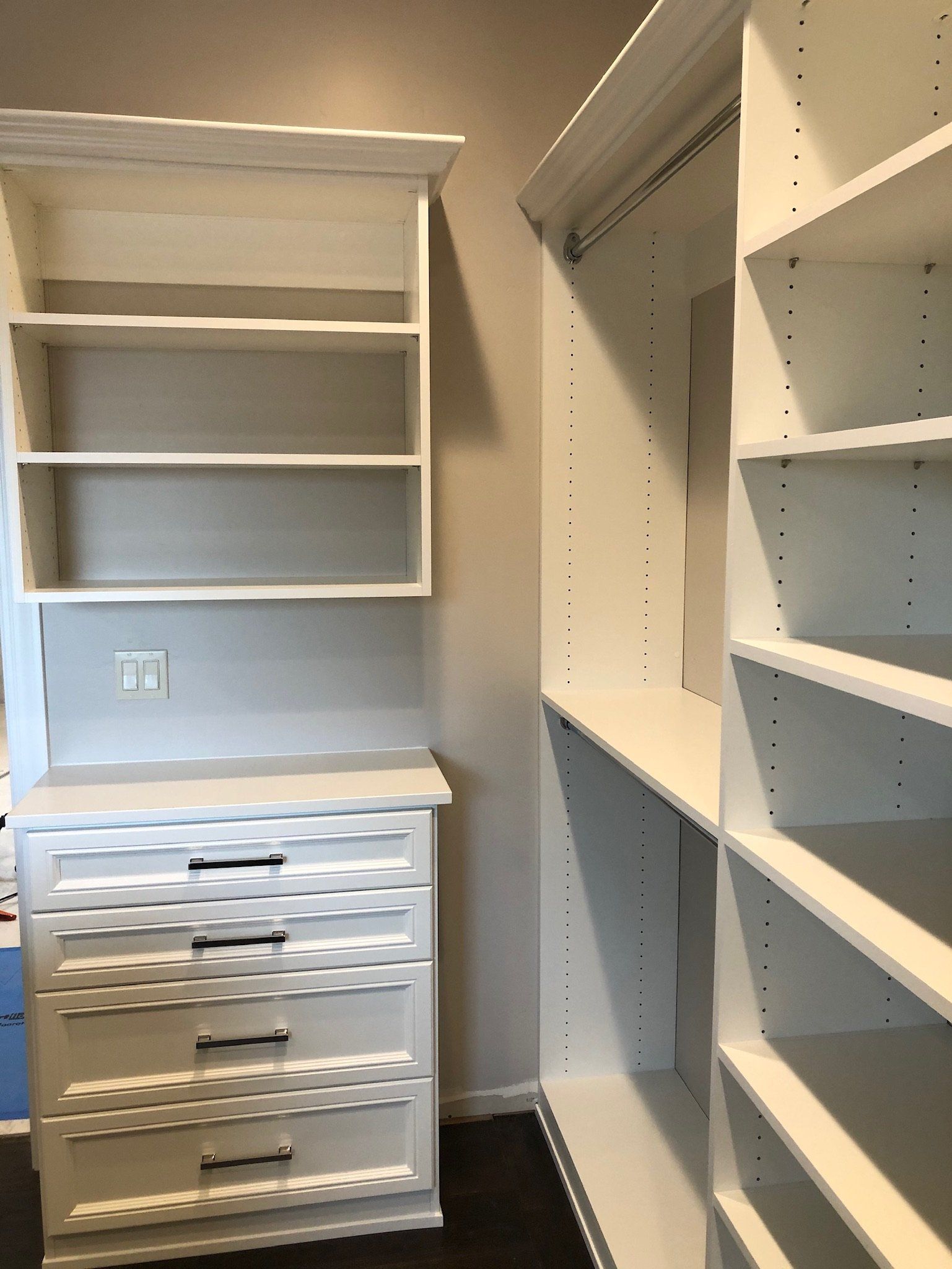 A walk in closet with lots of shelves and drawers
