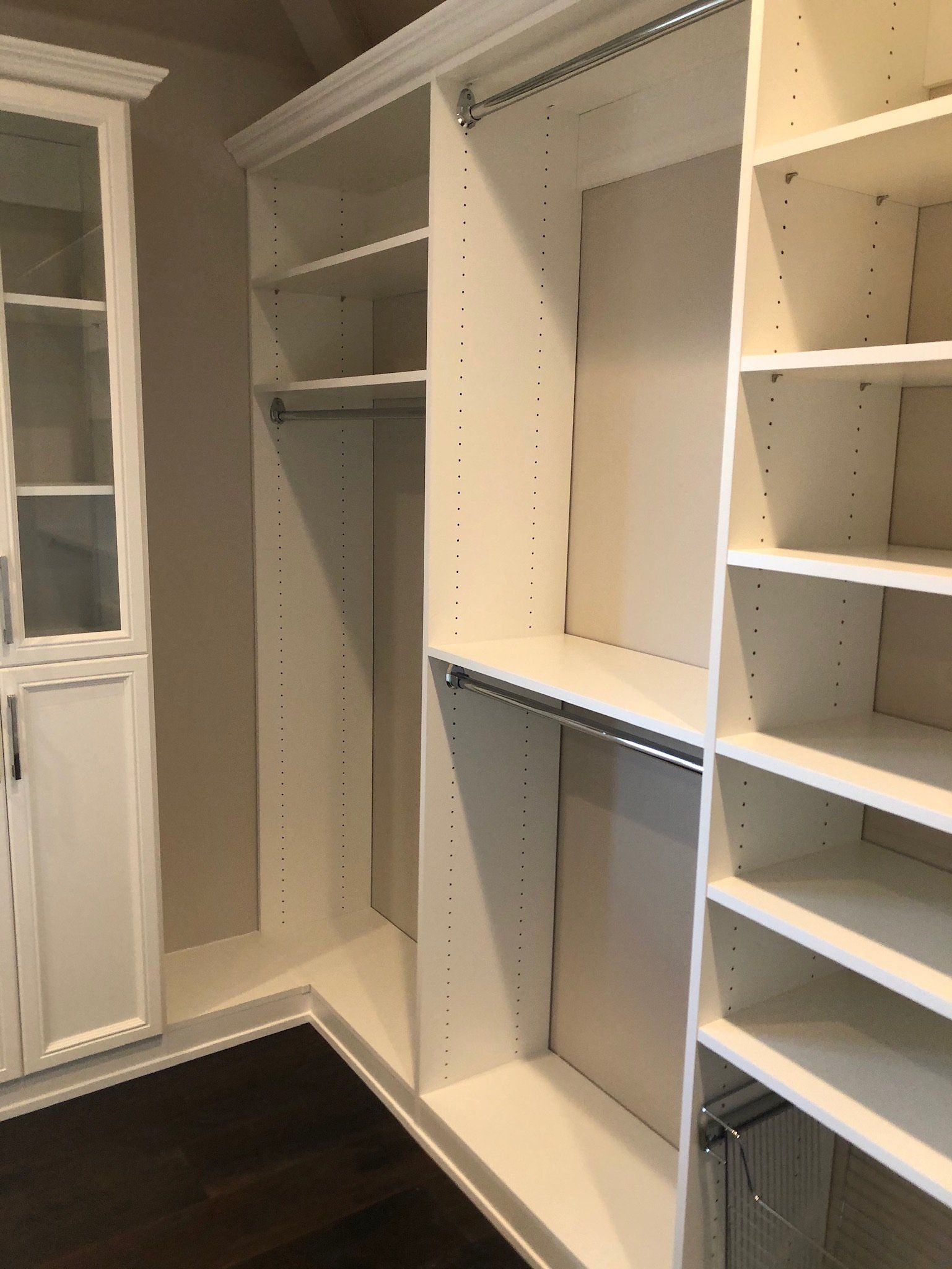 A walk in closet with lots of shelves and drawers