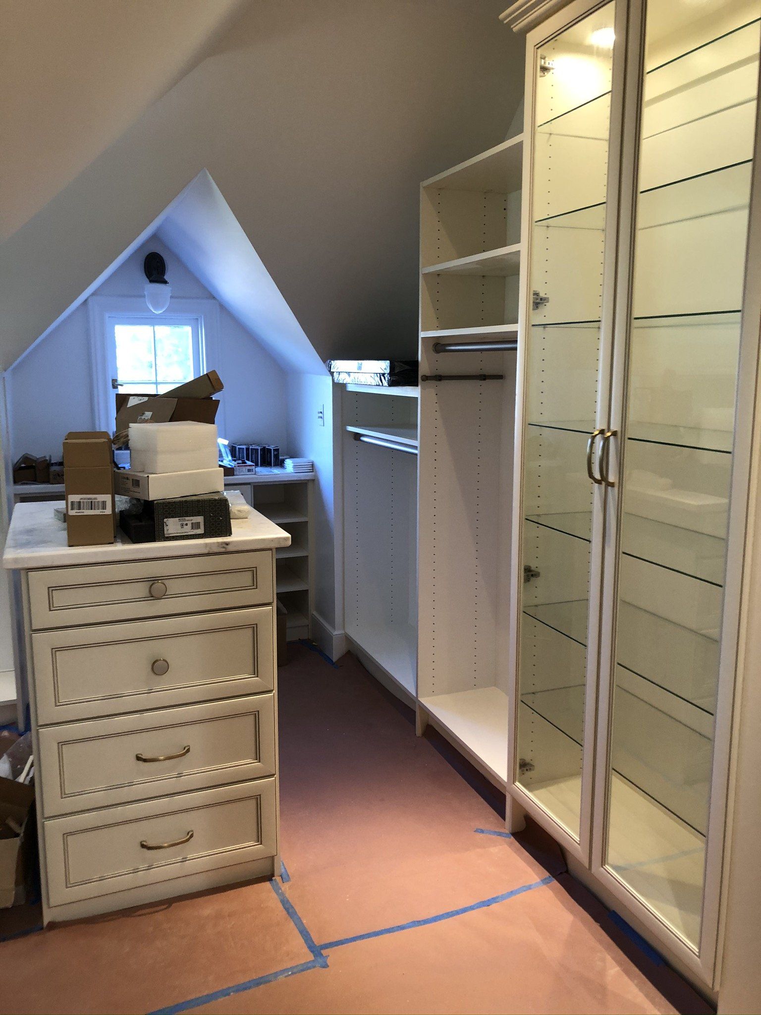 A walk in closet with a dresser and lots of shelves