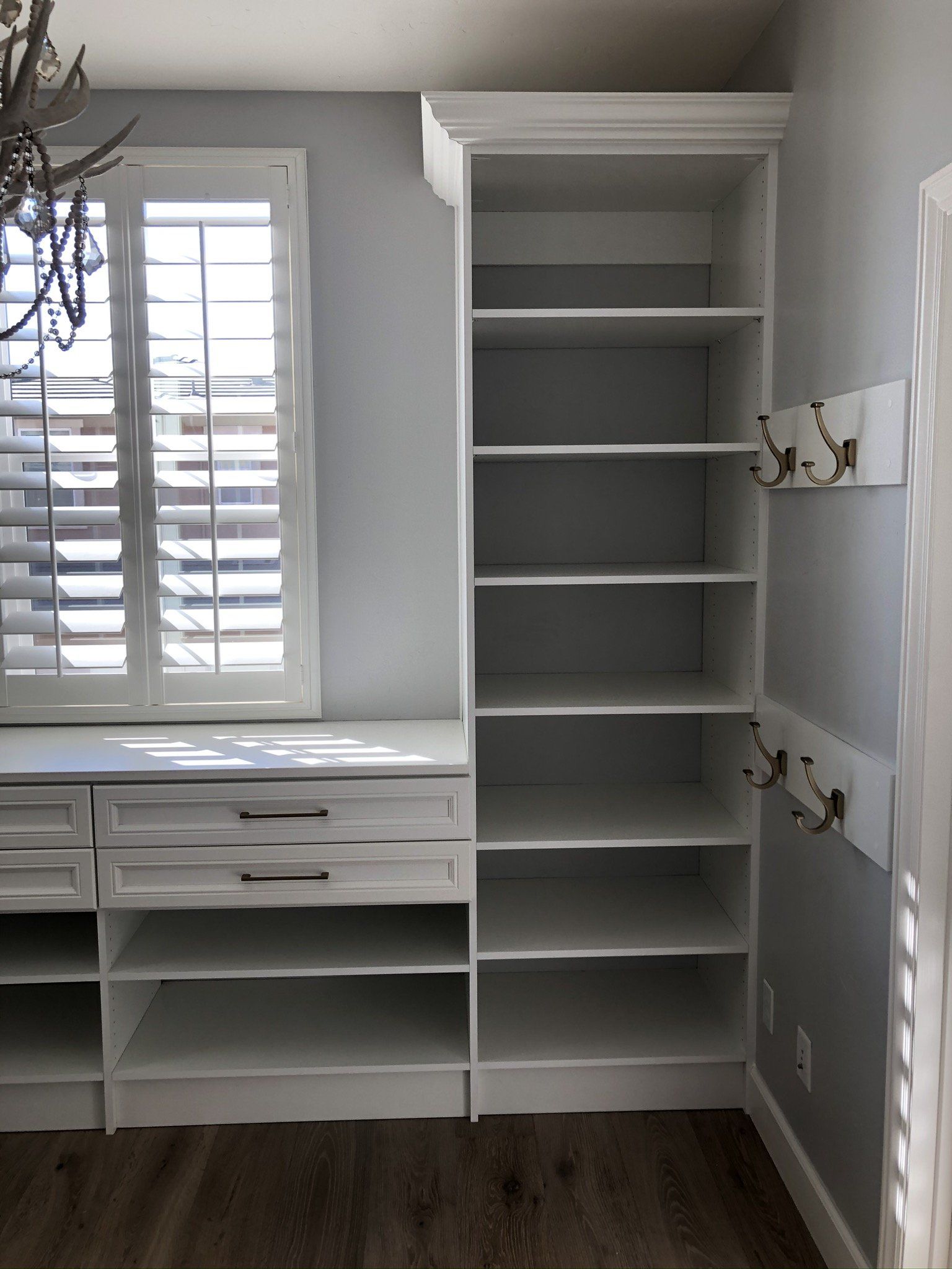 A room with a lot of shelves and a window