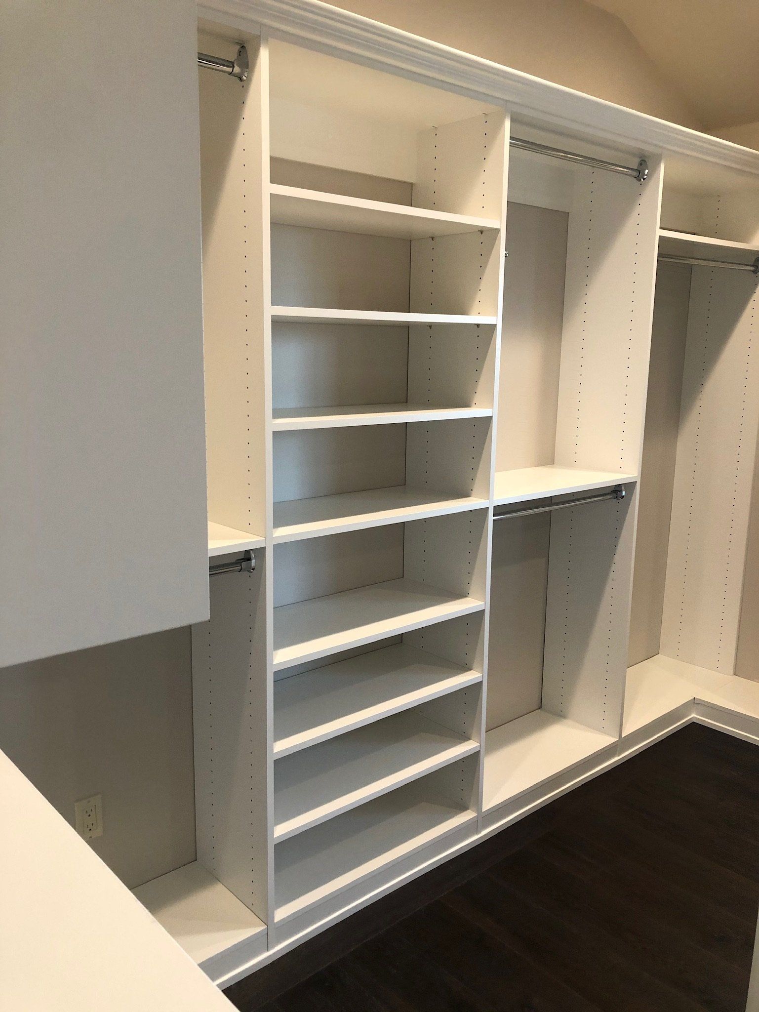 A walk in closet with lots of shelves and hanging racks