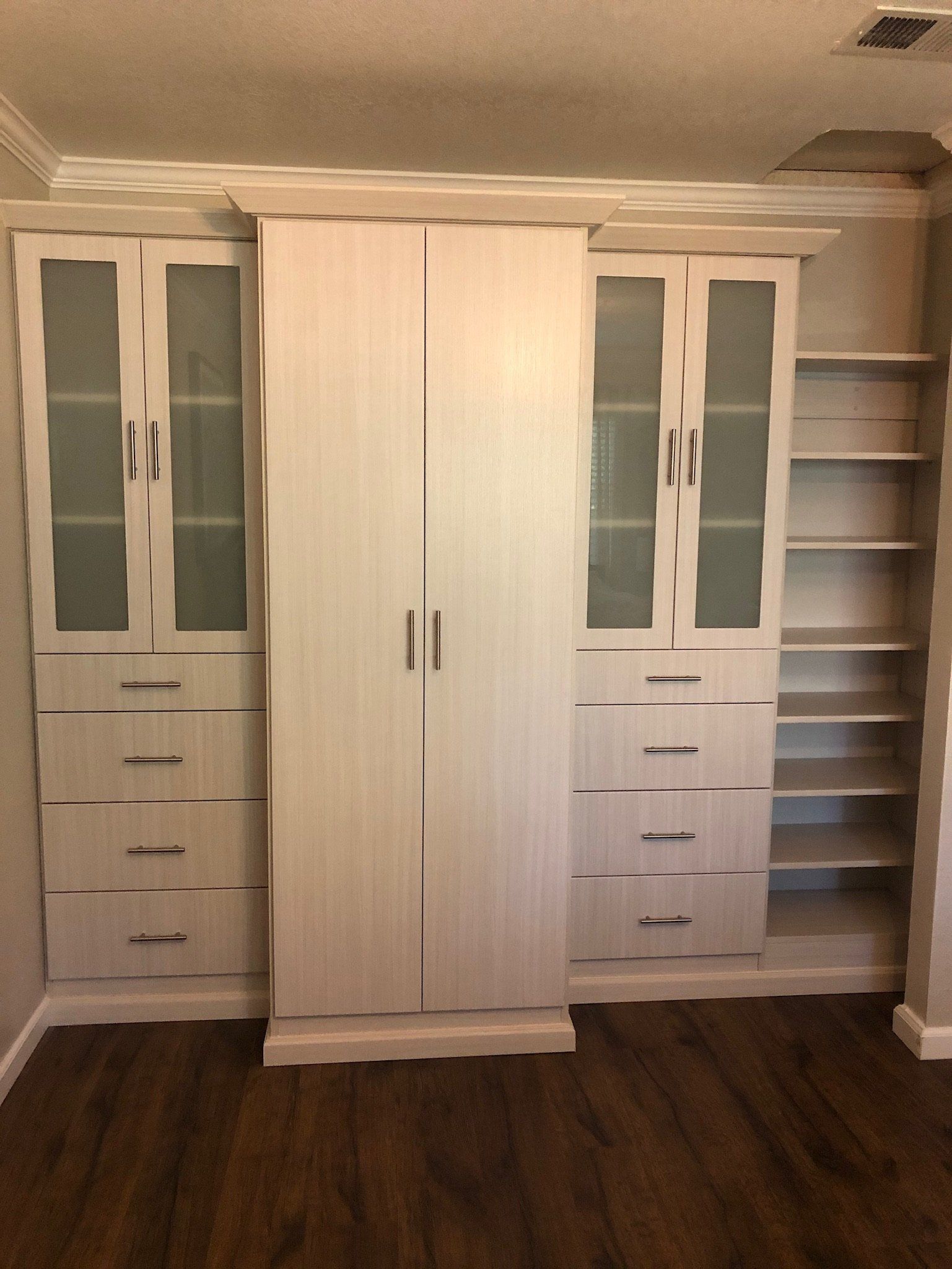 A room with a lot of white cabinets and shelves