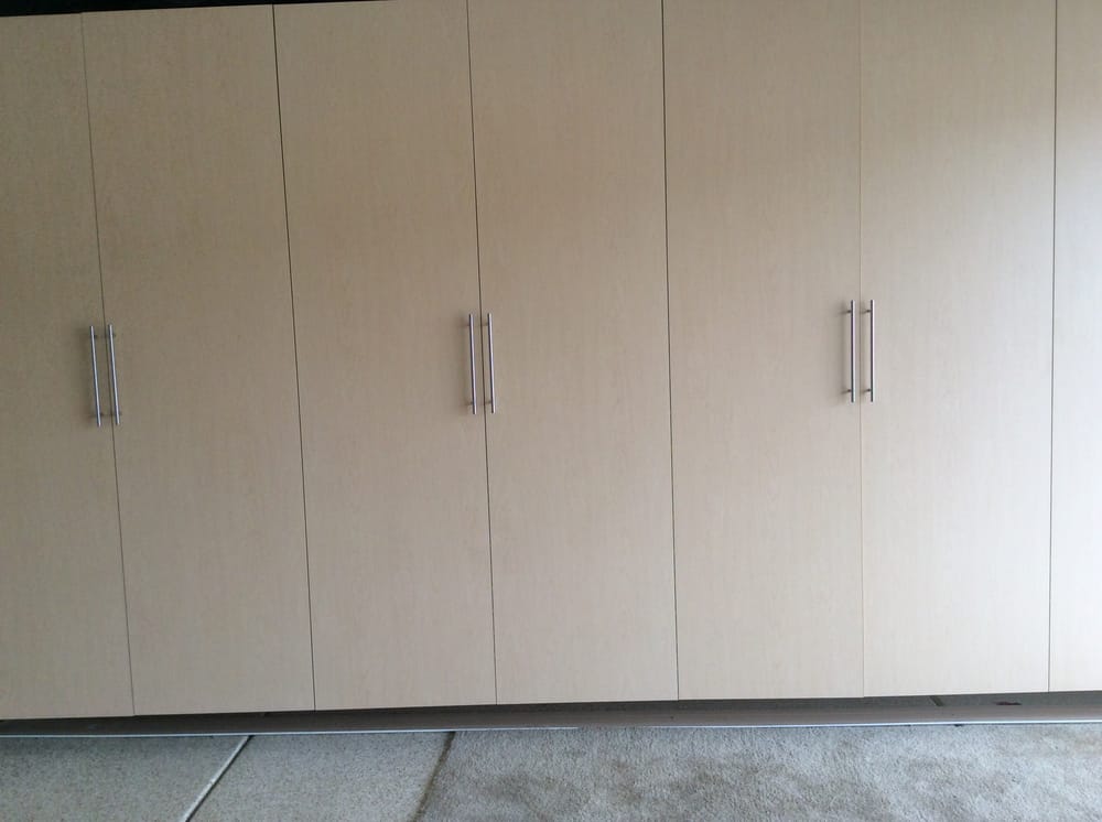 A garage with a lot of cabinets and a carpeted floor.