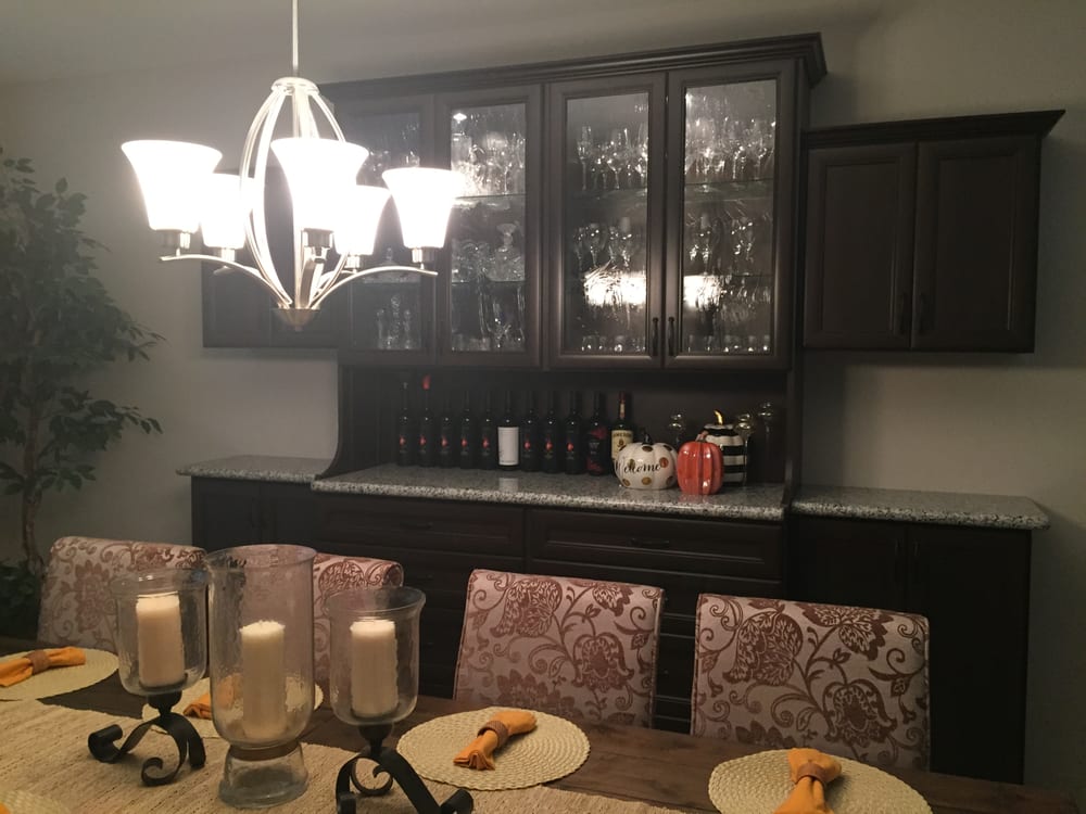 A dining room with a table and chairs and a chandelier