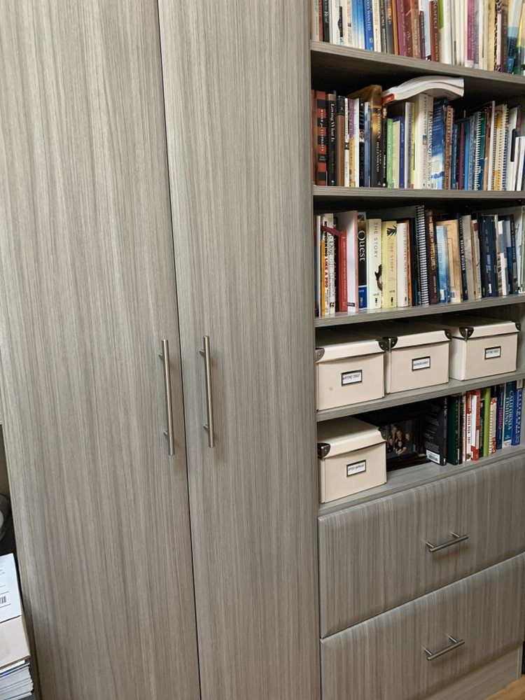 A bookcase filled with lots of books and boxes