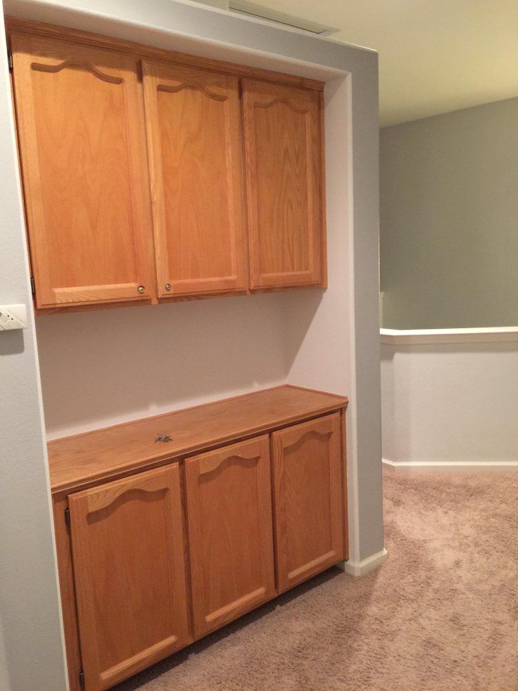 A room with wooden cabinets and a carpeted floor