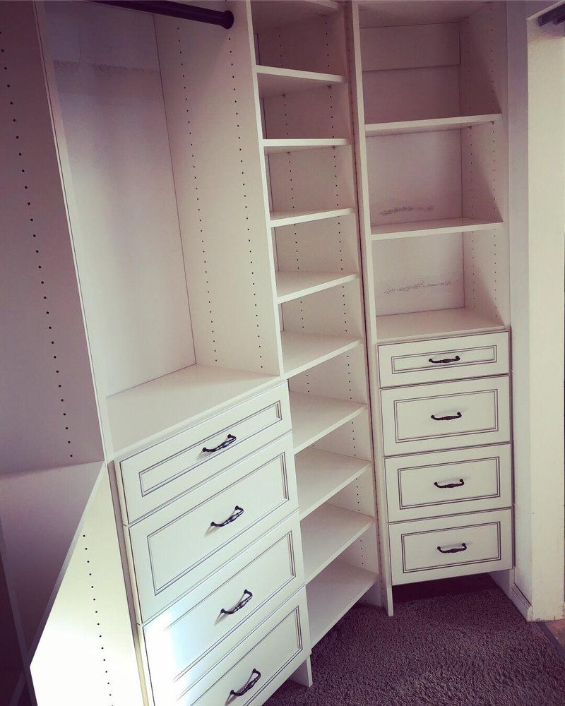 A walk in closet with lots of shelves and drawers