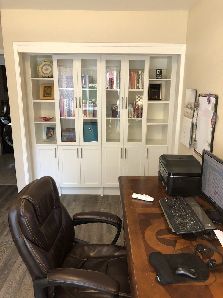A chair is sitting at a desk in front of a bookshelf.