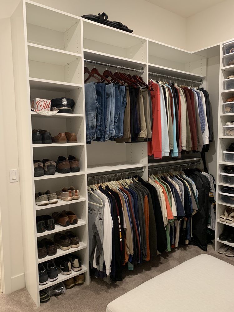 A walk in closet filled with lots of clothes and shoes.